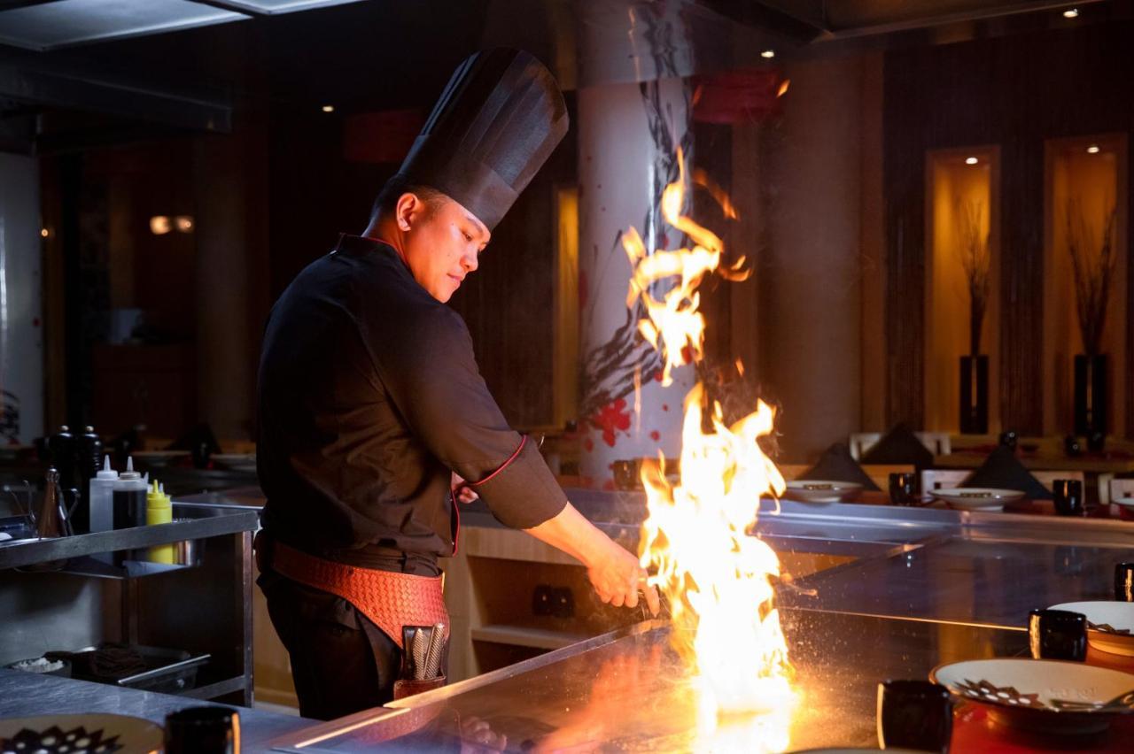 Beach Rotana - Abu Dhabi Bagian luar foto A chef cooking with a flaming torch